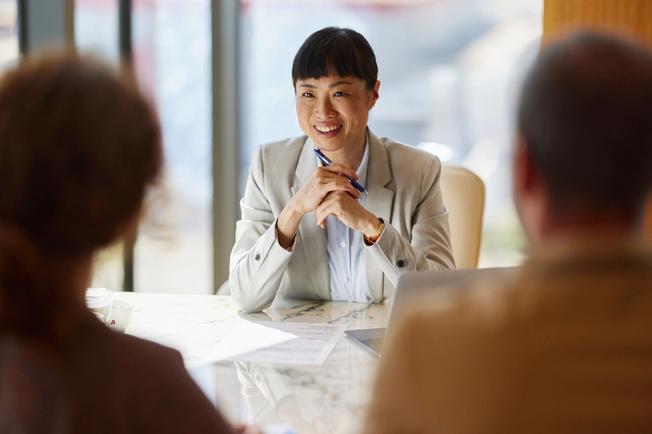 Happy Japanese advisor talking to her customers in the office.