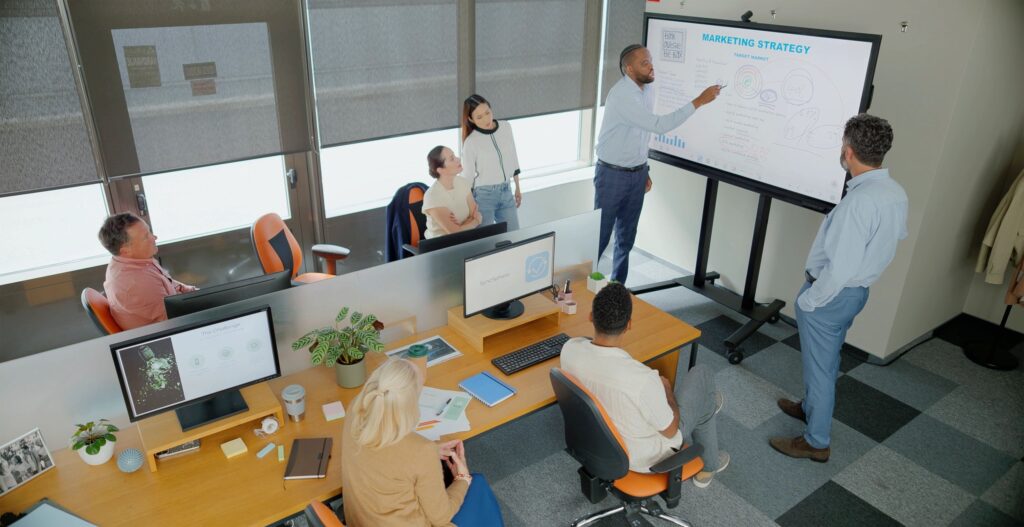 Diverse Business Team Collaborating During Interactive Whiteboard Presentation In Modern Office